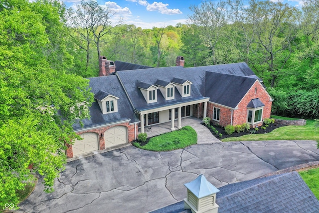 8602 Frontgate Ln, Indianapolis, IN 46256 - new england style home with a chimney, brick siding, a porch, and driveway
