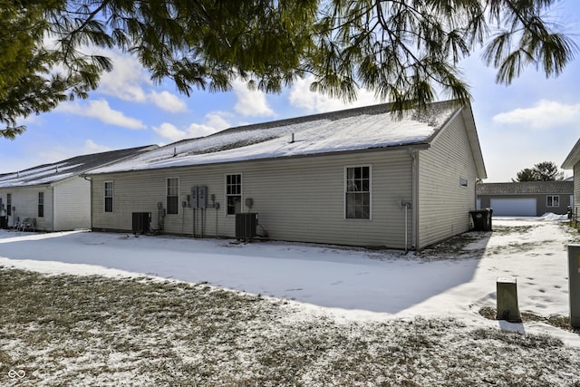 snow covered property with central AC unit