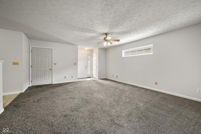 spare room featuring dark carpet, a textured ceiling, and ceiling fan