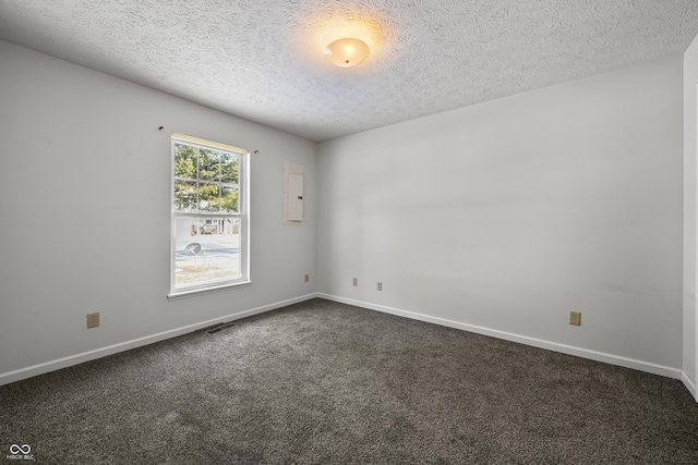 empty room featuring dark colored carpet and a textured ceiling