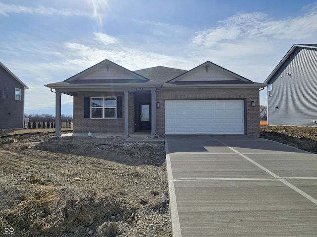 view of front facade with brick siding, concrete driveway, and a garage