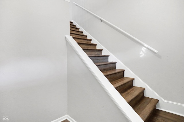 staircase with hardwood / wood-style flooring