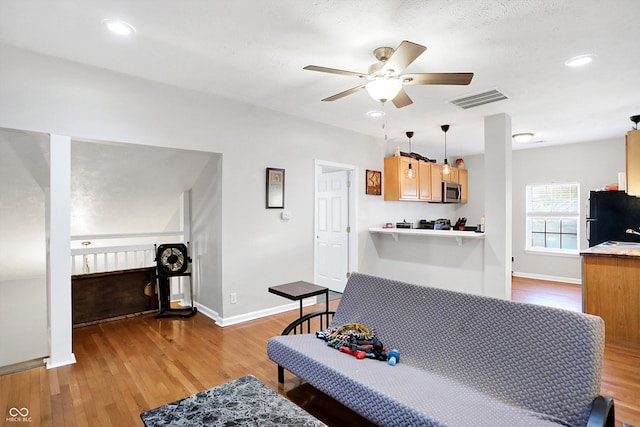 living room featuring hardwood / wood-style floors and ceiling fan