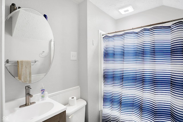 bathroom featuring a shower with curtain, vanity, a textured ceiling, and toilet