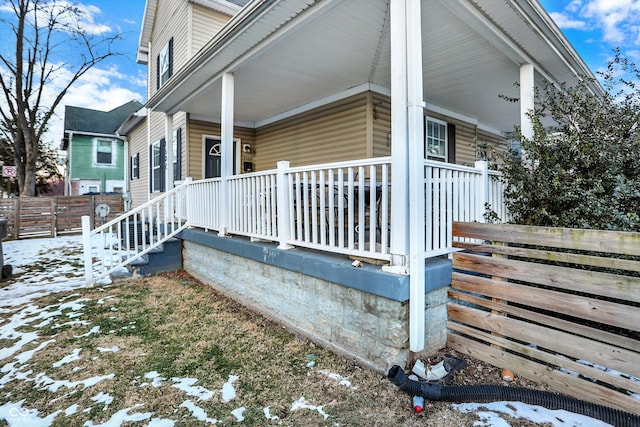 view of snowy exterior featuring a porch