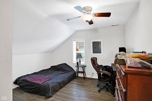 bedroom with vaulted ceiling, dark hardwood / wood-style flooring, electric panel, ceiling fan, and a textured ceiling