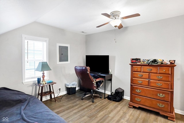 bedroom featuring ceiling fan, electric panel, vaulted ceiling, and light wood-type flooring