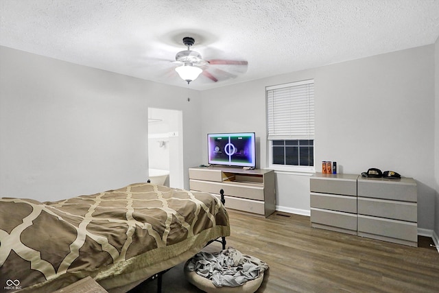 bedroom featuring dark hardwood / wood-style flooring, connected bathroom, a textured ceiling, and ceiling fan