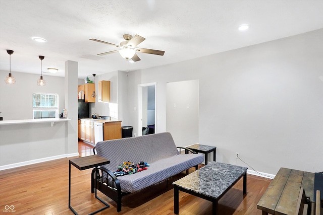 living room featuring sink, ceiling fan, and light hardwood / wood-style flooring