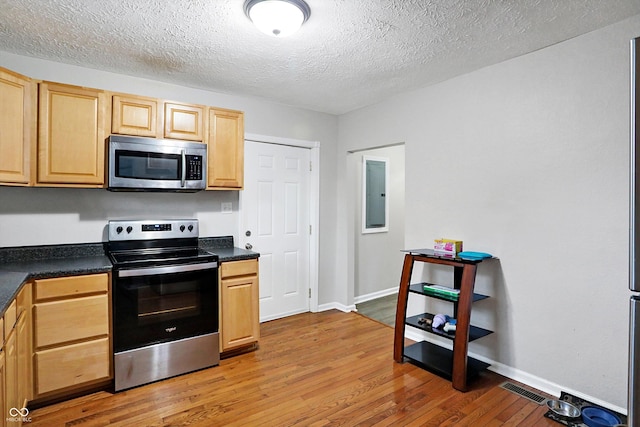 kitchen with stainless steel appliances, electric panel, light hardwood / wood-style floors, a textured ceiling, and light brown cabinets