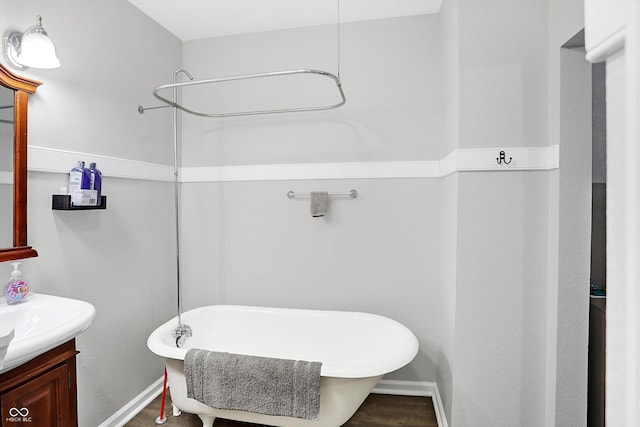 bathroom with hardwood / wood-style flooring, vanity, and a washtub