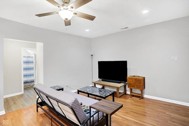 living room featuring ceiling fan and light hardwood / wood-style flooring