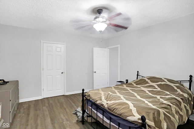 bedroom featuring ceiling fan, dark hardwood / wood-style flooring, and a textured ceiling