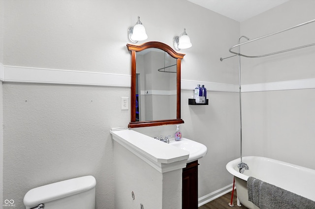 bathroom with vanity, a bath, and toilet