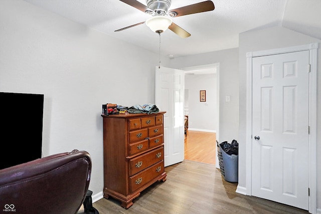 office space featuring ceiling fan, lofted ceiling, and light hardwood / wood-style floors