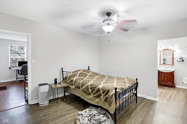 bedroom featuring a textured ceiling, wood-type flooring, ceiling fan, and ensuite bathroom