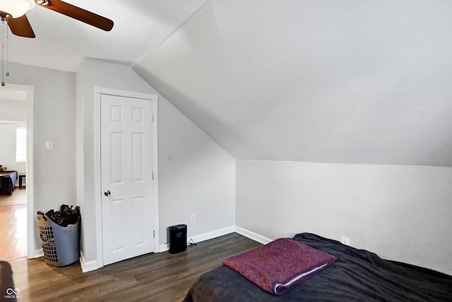 bedroom featuring dark hardwood / wood-style flooring, lofted ceiling, and ceiling fan