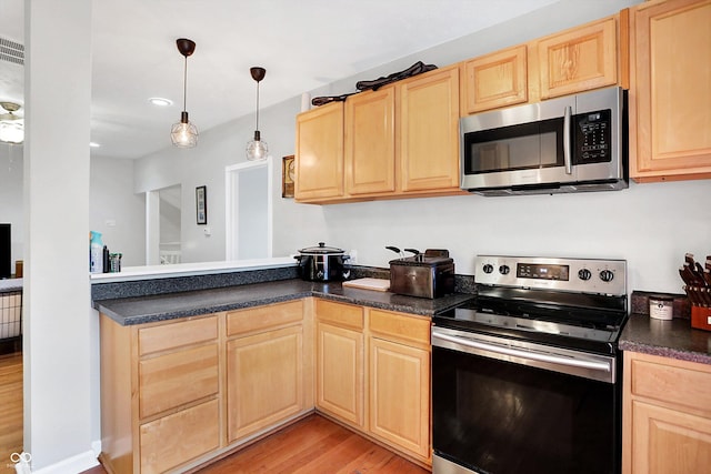 kitchen featuring appliances with stainless steel finishes, light brown cabinets, light hardwood / wood-style floors, and decorative light fixtures