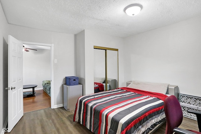 bedroom featuring dark hardwood / wood-style floors, a textured ceiling, and a closet