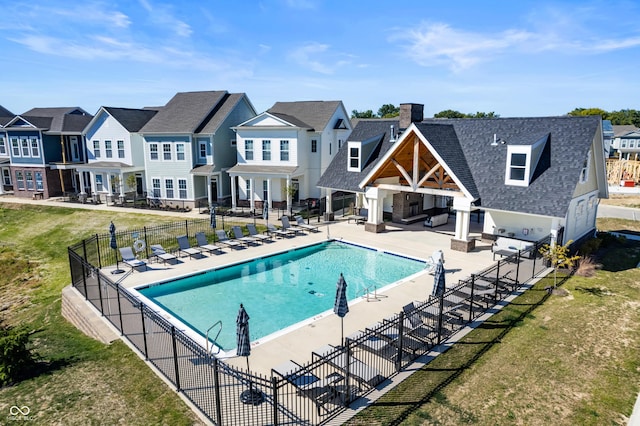 view of pool with a patio and a lawn