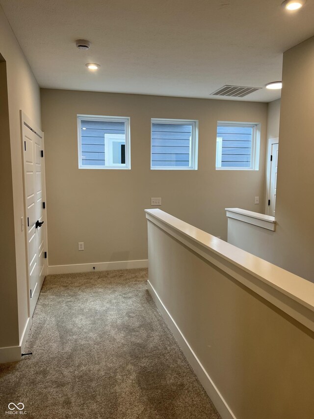 hall featuring visible vents, recessed lighting, carpet, and baseboards