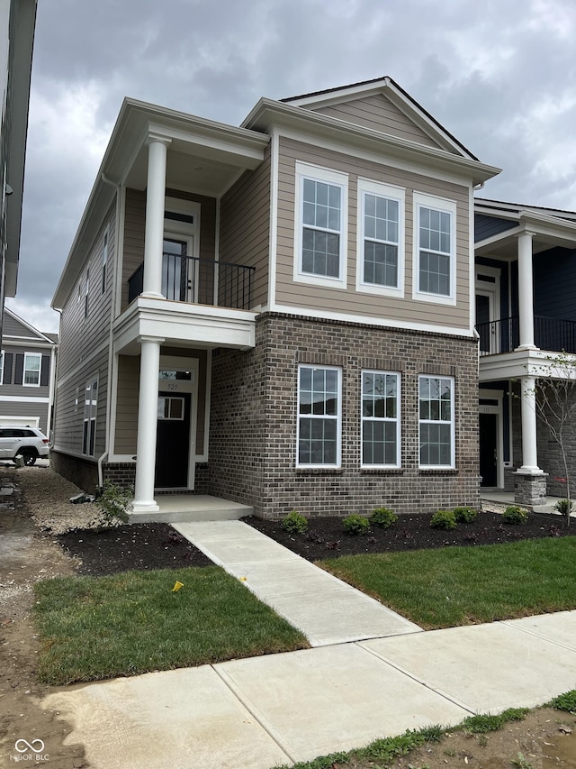 view of front of home with brick siding and a balcony