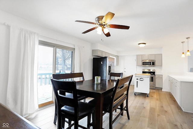 dining space featuring ceiling fan and light wood-type flooring