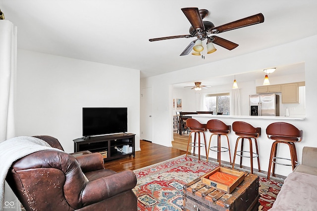 living room featuring dark wood-type flooring and ceiling fan