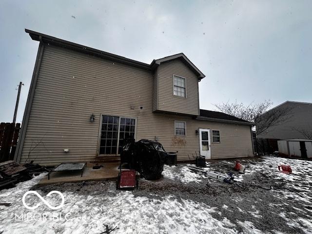 view of snow covered rear of property