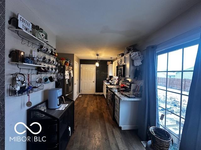 kitchen featuring dark wood-type flooring, pendant lighting, and black appliances