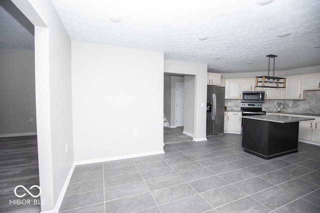 kitchen featuring hanging light fixtures, stainless steel appliances, a center island, tasteful backsplash, and light stone counters