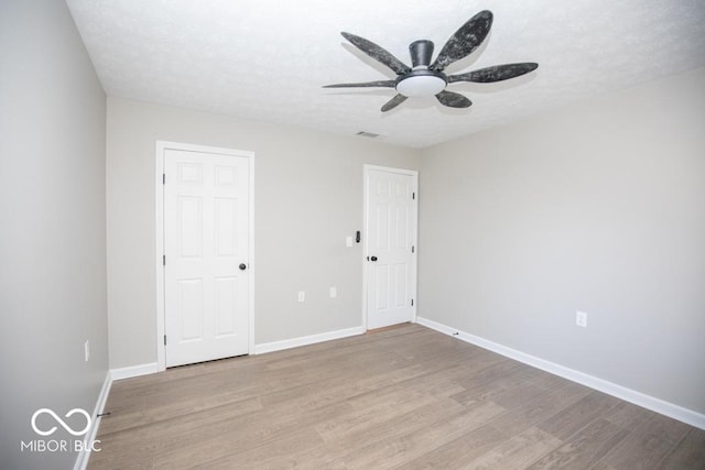 unfurnished room featuring ceiling fan, a textured ceiling, and light hardwood / wood-style flooring