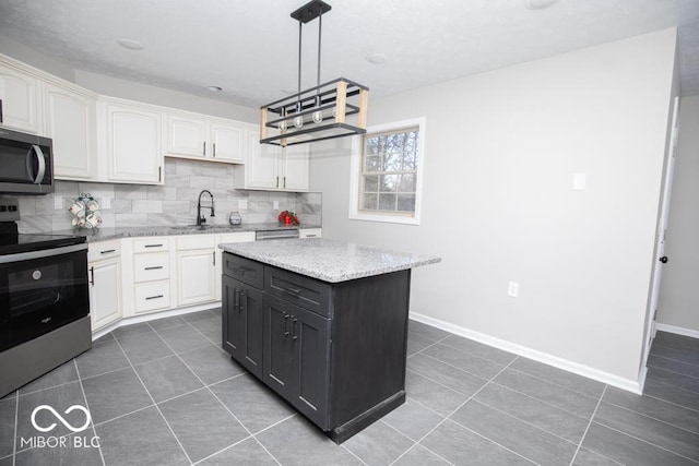 kitchen featuring sink, decorative light fixtures, a kitchen island, stainless steel appliances, and white cabinets