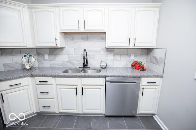 kitchen with white cabinetry, sink, stainless steel dishwasher, and dark tile patterned flooring