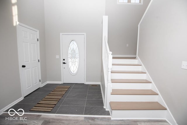 tiled entrance foyer with a healthy amount of sunlight and a high ceiling