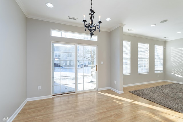 interior space with ornamental molding, plenty of natural light, a chandelier, and light hardwood / wood-style floors