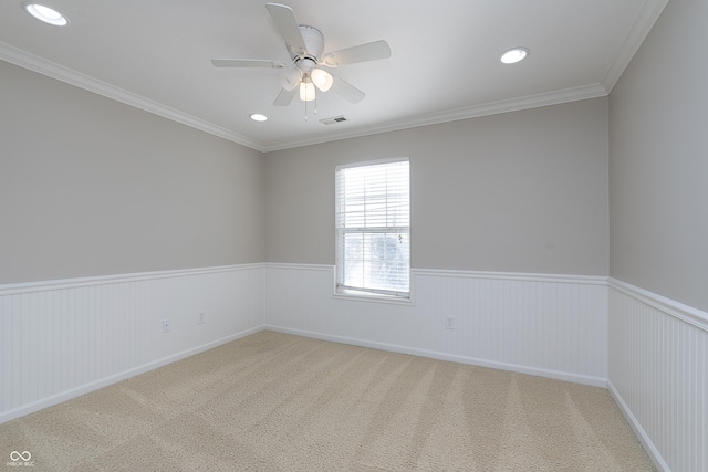 empty room featuring crown molding, ceiling fan, and carpet flooring