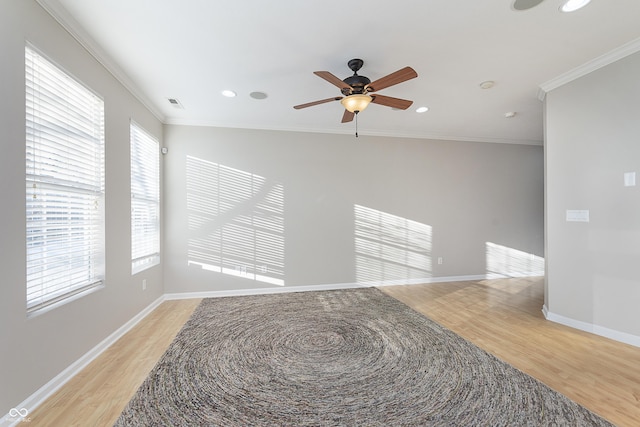 empty room featuring ornamental molding, ceiling fan, and light wood-type flooring