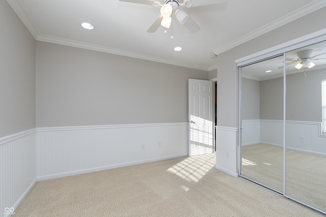 unfurnished bedroom with crown molding, carpet floors, ceiling fan, and a closet