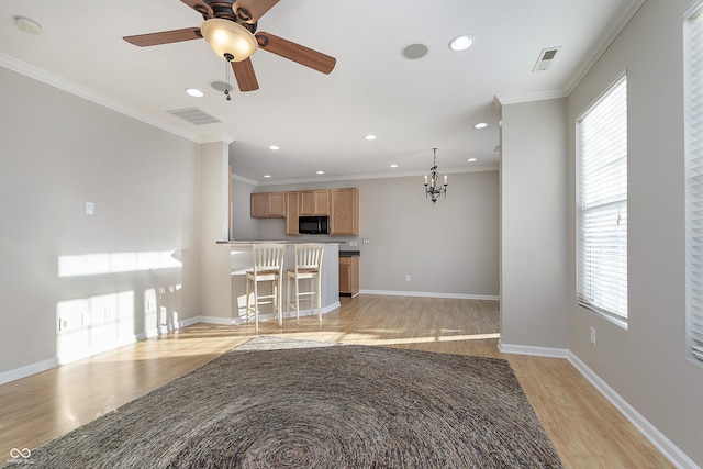 interior space featuring ceiling fan with notable chandelier, ornamental molding, and light wood-type flooring