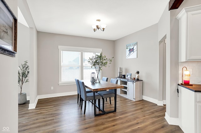 dining area featuring dark hardwood / wood-style floors and an inviting chandelier