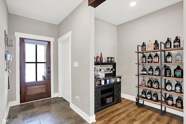 entryway with dark wood-type flooring and bar area