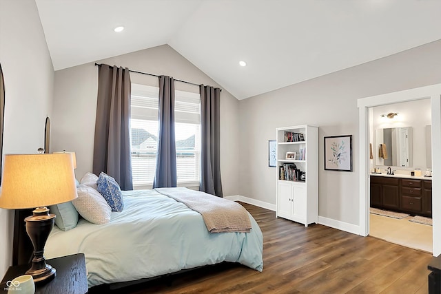 bedroom with connected bathroom, dark wood-type flooring, sink, and vaulted ceiling