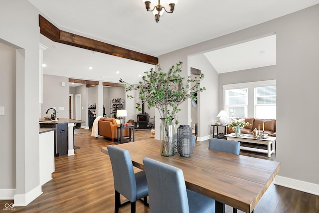 dining room with sink, dark hardwood / wood-style floors, and lofted ceiling with beams