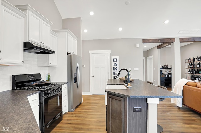 kitchen with stainless steel fridge, backsplash, light hardwood / wood-style floors, white cabinets, and black range with gas stovetop