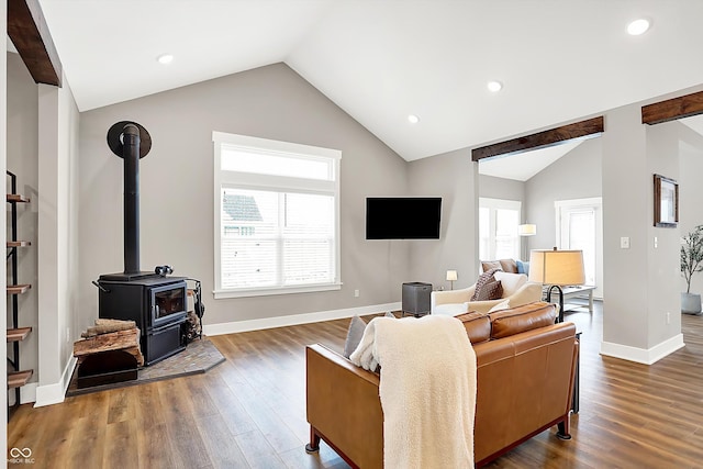 living room with dark hardwood / wood-style floors, vaulted ceiling, and a wood stove