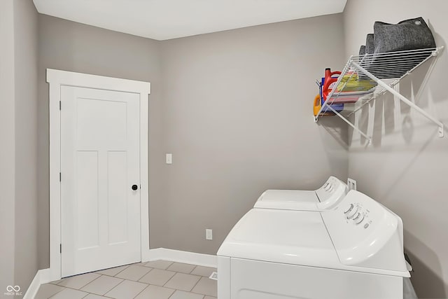 laundry room featuring washing machine and dryer and light tile patterned floors