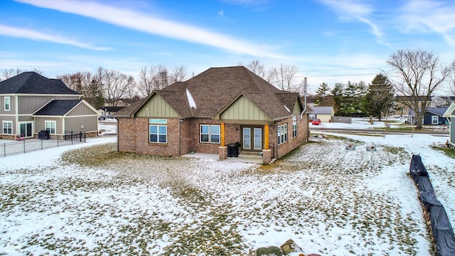 view of snow covered back of property