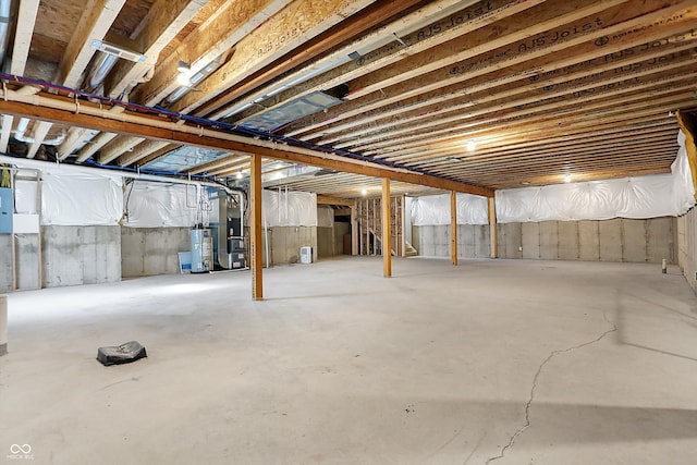 basement with heating unit, electric panel, and water heater