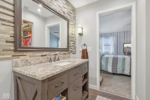 bathroom featuring vanity, backsplash, and wood-type flooring